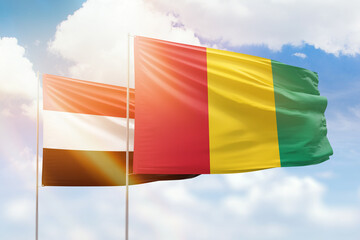 Sunny blue sky and flags of guinea and yemen
