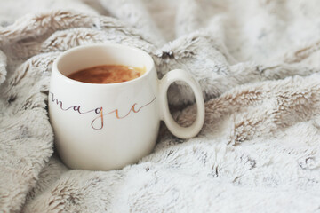 Mug with hot morning coffee on white plaid