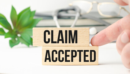 claim accepted words on wooden background and stethoscope