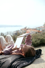 Baby girl reading book on the old city background. Stambul lanscape.