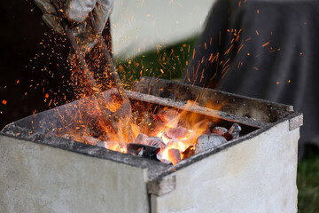 Fire sparks in a forge, ticks with a billet in the blacksmith hand. Hot coals in medieval smithy