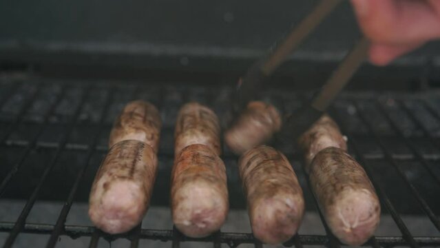Spicy Sausages Being Grilled Over Bright Glowing Coals Broasting On Fire. Lunch Celebration Party Barbecue. Outdoor Cooking. Cook Prepares Oriental Dish In Kitchen. Junk Food, Healthy Lifestyle.
