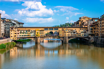 Fototapeta na wymiar Ponte Vecchio (old Bridge) in Florence, Tuscany, Italy. This medieval stone bridge that spans river Arno, consists of three segmental arches and it has always hosted shops and merchants.