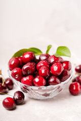Fresh organic sweet cherry in a plate on the table. Vertical composition.