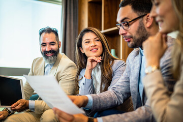 Teamwork. Team discussing something and smiling while sitting at the modern business lounge.
