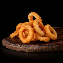 selective focus. fried onion rings in breadcrumbs fried in oil. restaurant serving. on a dark background. for menus and ads