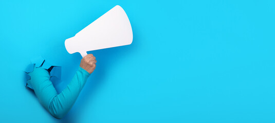 megaphone in hand over blue background, panoramic layout