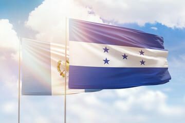 Sunny blue sky and flags of honduras and guatemala