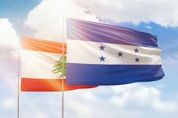 Sunny blue sky and flags of honduras and lebanon