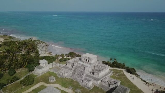 Aerial footage of Tulum Ruins, drone moves forward until it passes the pyramid and there is only turquoise caribbean left on the view. Probably the most iconic mayan ruins in the Yucatan Peninsula