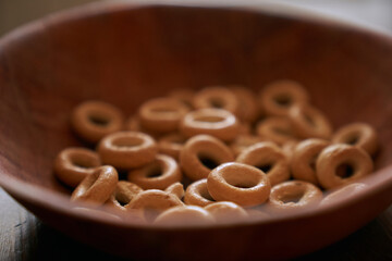 A bunch of round dryers in a wooden plate, on the table. Close-up, side view. High quality photo