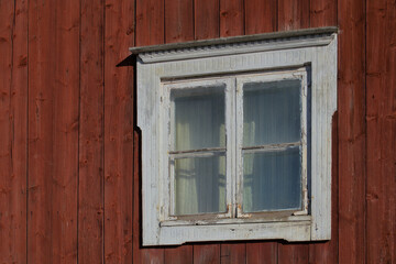 An old window in a bright wooden village house.