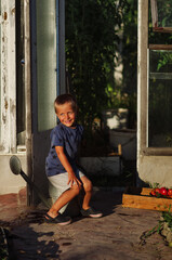 Portrait of little boy holding ripe tomatoes in the greenhouse