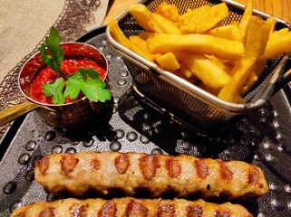 Grilled kabobs with fries and spice in plate