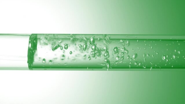 Transparent liquid flows in glass tube creating transparent different sized bubbles with on green background | Abstract face care cosmetics formulating concept