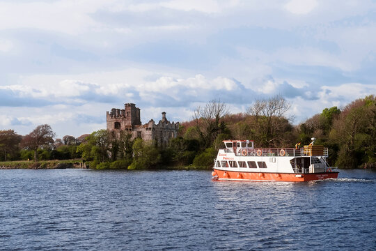 Galway, Ireland. 4.22.2022: Corrib river. Corrib princess cruise ship with tourists onboard. Blue cloudy sky. Popular tourist tour. Exploring Irish Nature and history concept.