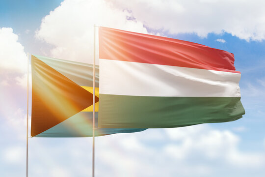 Sunny blue sky and flags of hungary and bahamas