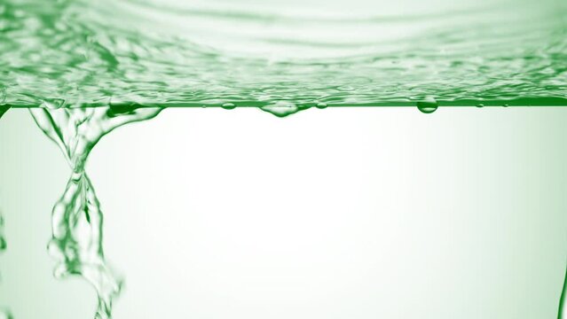 Green liquid is flowing down from glass surface on green background | Background shot for skincare cosmetics advertisement