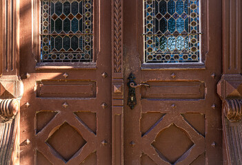 Old brown vintage doors with stained glass windows.
