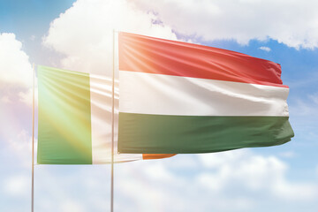 Sunny blue sky and flags of hungary and ireland