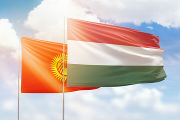 Sunny blue sky and flags of hungary and kyrgyzstan