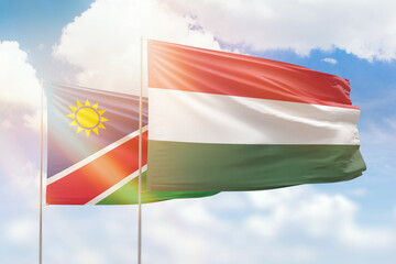 Sunny blue sky and flags of hungary and namibia