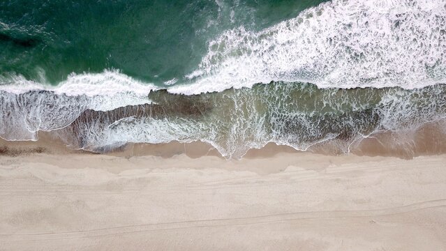 large waves of the ocean meet a beach, aerial view, sea level, coast, sea, high quality image