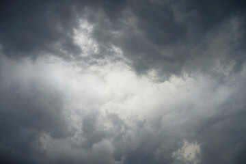 Dark, gloomy, stormy, rainy sky with rays of light. Terrible hurricane clouds. Background image for...