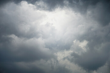Dark, gloomy, stormy, rainy sky with rays of light. Terrible hurricane clouds. Background image for design