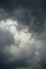Dark, gloomy, stormy, rainy sky with rays of light. Terrible hurricane clouds. Background image for design