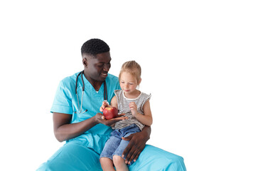 a caring African-American pediatrician treats a little girl patient with an apple and talks about healthy eating. The concept of proper nutrition.