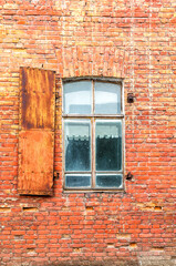 Old building brick wall with an window with hinged shutters