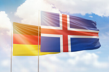 Sunny blue sky and flags of iceland and germany