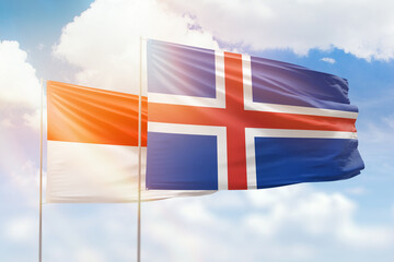 Sunny blue sky and flags of iceland and indonesia