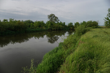Evening landscape with the last rays of the sun. Morning by the river in summer. Beautiful nature, photo for design