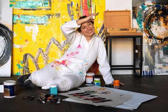 MUJER EN EL SUELO PINTANDO EN SU ESTUDIO. 