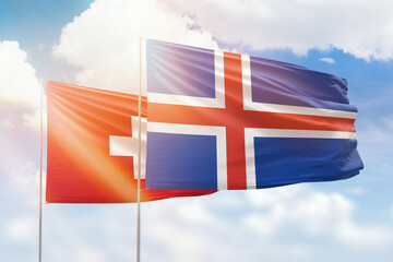 Sunny blue sky and flags of iceland and switzerland