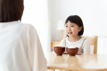 お母さんとご飯を食べる女の子