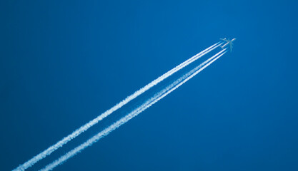 Airplane with a long reverse trail in the blue sky