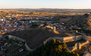 Fototapeta na wymiar Scenic drone view of ancient ruined Mocha tower or Consolation Castle on hilltop surrounded by remains of fortified walls on background of Calatayud townscape in spring, Spain