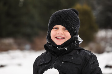 Fototapeta na wymiar Young boy playing in snowy winter wonderland