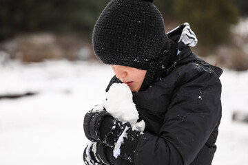 Fototapeta na wymiar Young boy playing in snowy winter wonderland