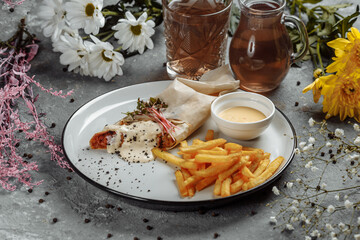 Shawarma Sandwich with French Fires and Salt Grinder on Dark Background