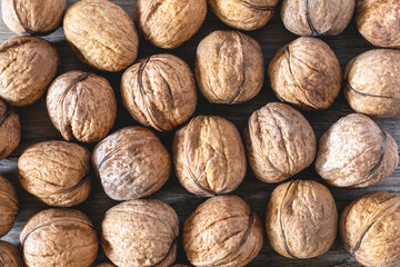 Background of whole walnuts on a wooden table. Natural and healthy food, close up