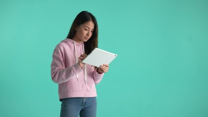 Thoughtful young woman with tablet thinking over idea, smiling satisfied with right decision and frowning when idea slips away. Portrait of pensive asian girl working on project isolated on background