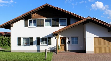 Fototapeta na wymiar Einfamilienhaus mit Garage in ländlicher Umgebung, Allgäu, Bayern.