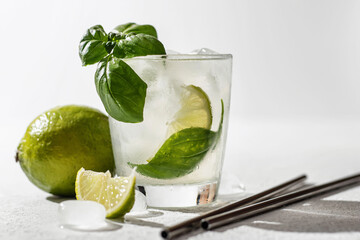 Refreshing infused water with citrus lime and basil with metal straws. Wellness concept