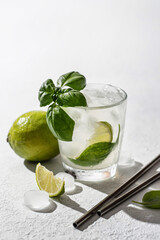 Refreshing infused water with citrus lime and basil with metal straws. Wellness concept