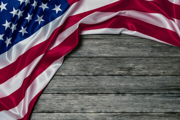 AMERICAN FLAG WITH CREASES AND FOLDS ON OLD WOODEN PLANKS BACKGROUND. MEMORIAL DAY CONCEPT AND INDEPENDENCE DAY CELEBRATIONS. COPY SPACE.