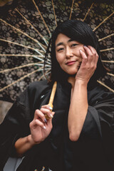 Portrait of sexy and young japanese woman with beautiful old traditional black kimono and lace sun...